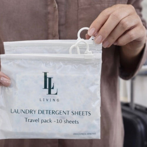 Person holding a package of laundry detergent sheets with 'LL Living' branding.