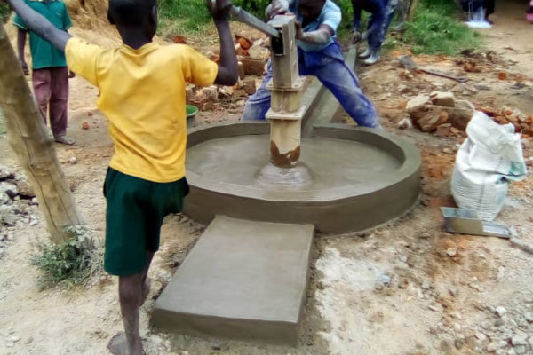 children in Uganda pumping water from a newly built well