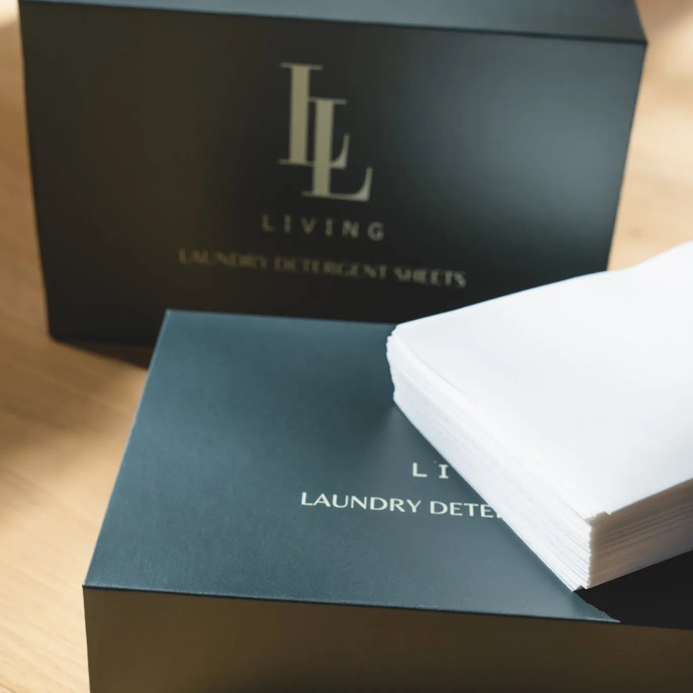 Boxes of laundry detergent sheets with 'LL Living' branding on a wooden surface.