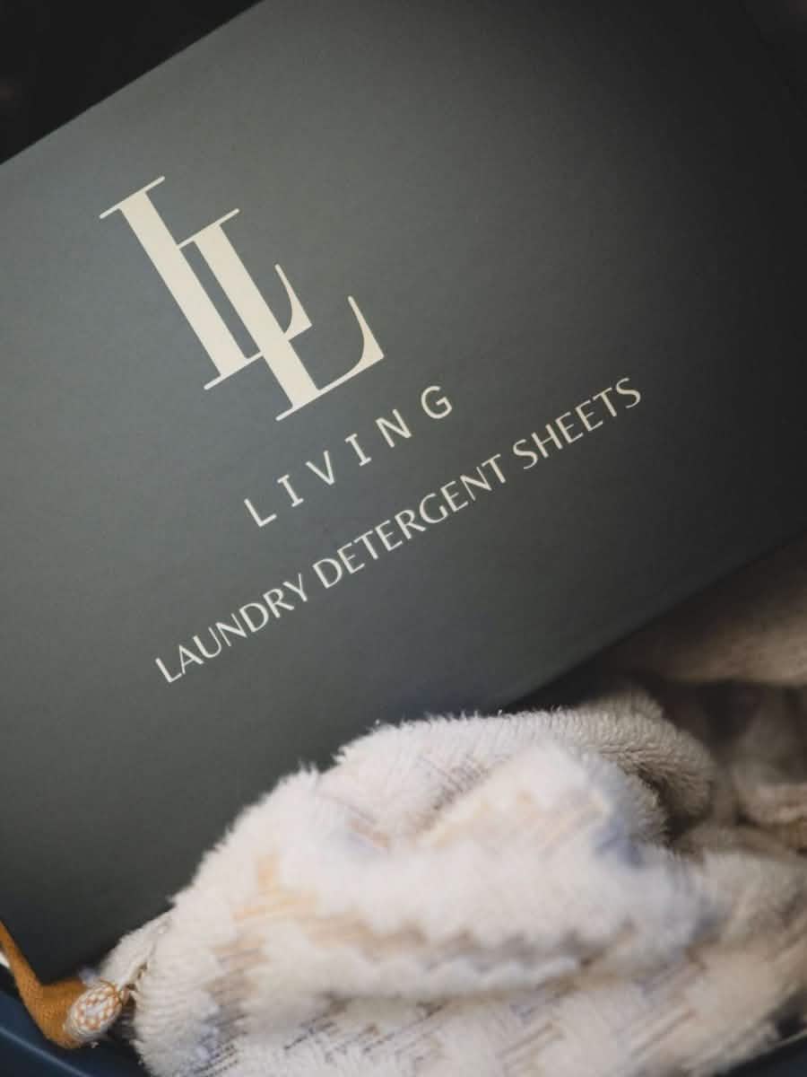 Box of hypoallergenic laundry detergent sheets with a brand logo on a textured surface.