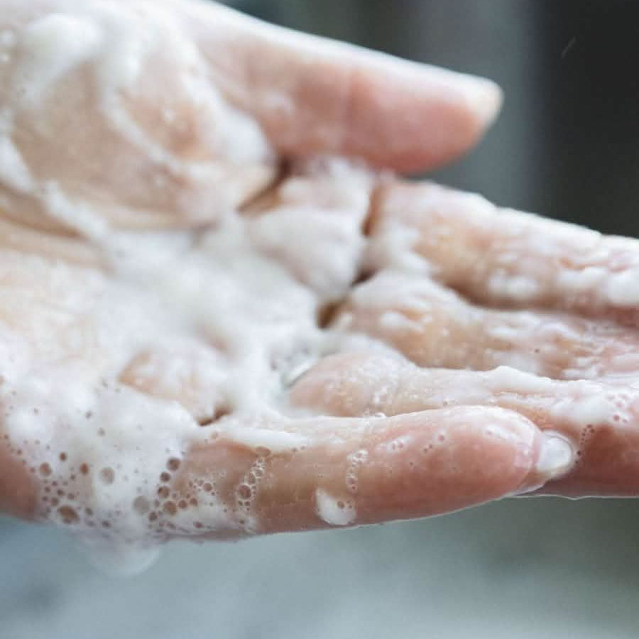 skin-friendly detergent soap suds in a blurred bathroom setting