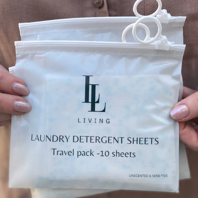 Pack of unscented laundry detergent sheets travel size held by a person wearing a brown shirt.