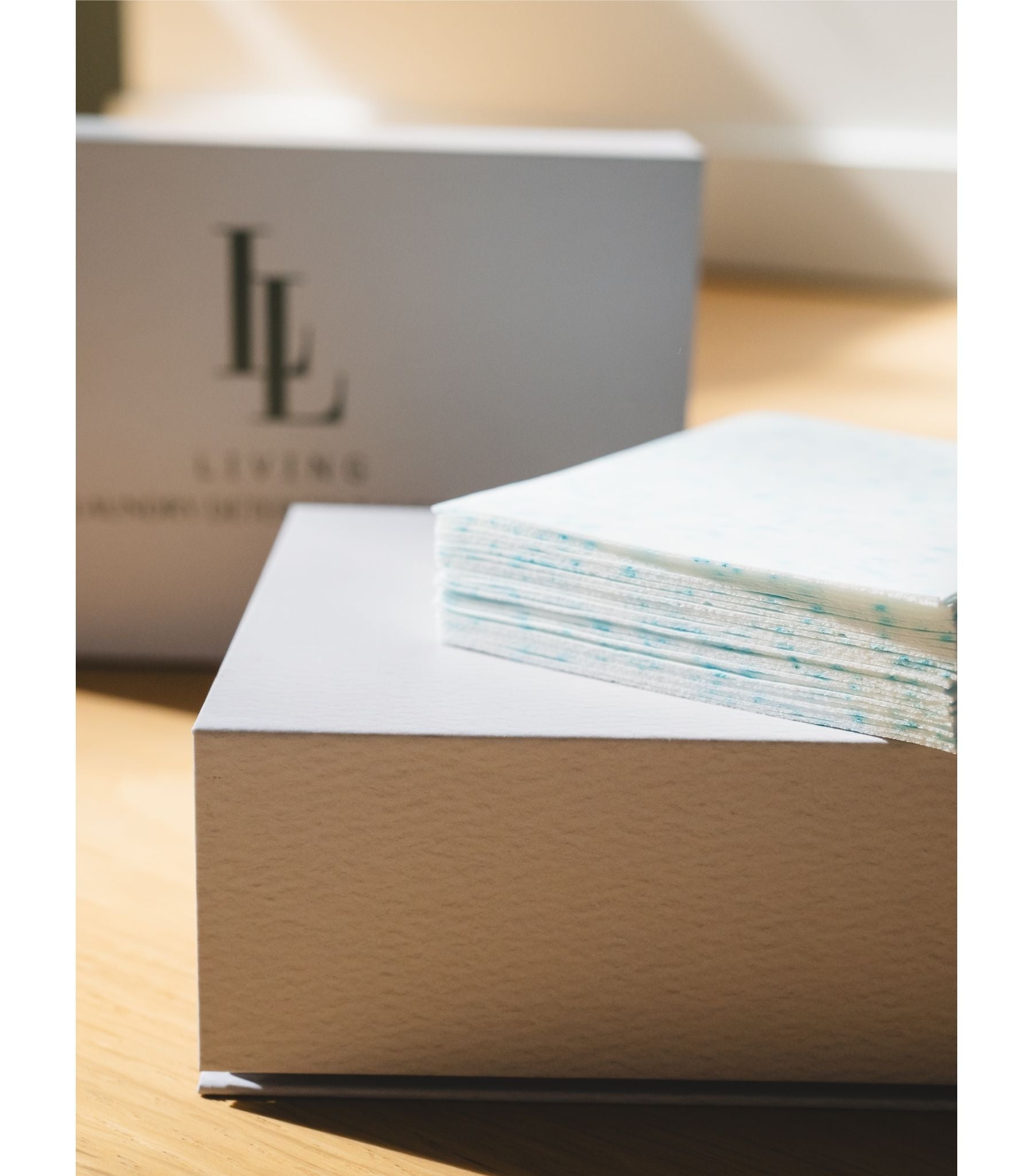 Stack of papers on a desk with a box labeled 'LL' in the background