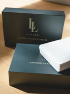 Boxes of laundry detergent sheets with 'LL Living' branding on a wooden surface.