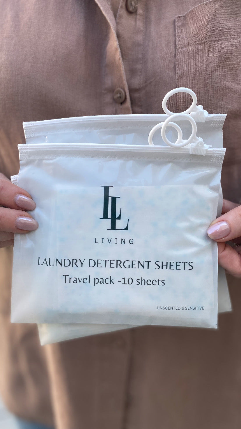 Pack of unscented laundry detergent sheets travel size held by a person wearing a brown shirt.
